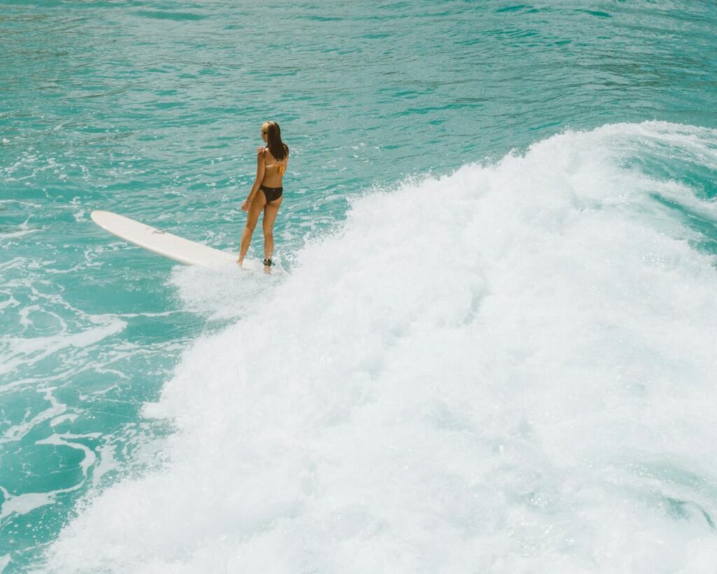 pexels-photo-4601771 Aerial view of a surfer catching a wave in the clear blue Hawaiian ocean.