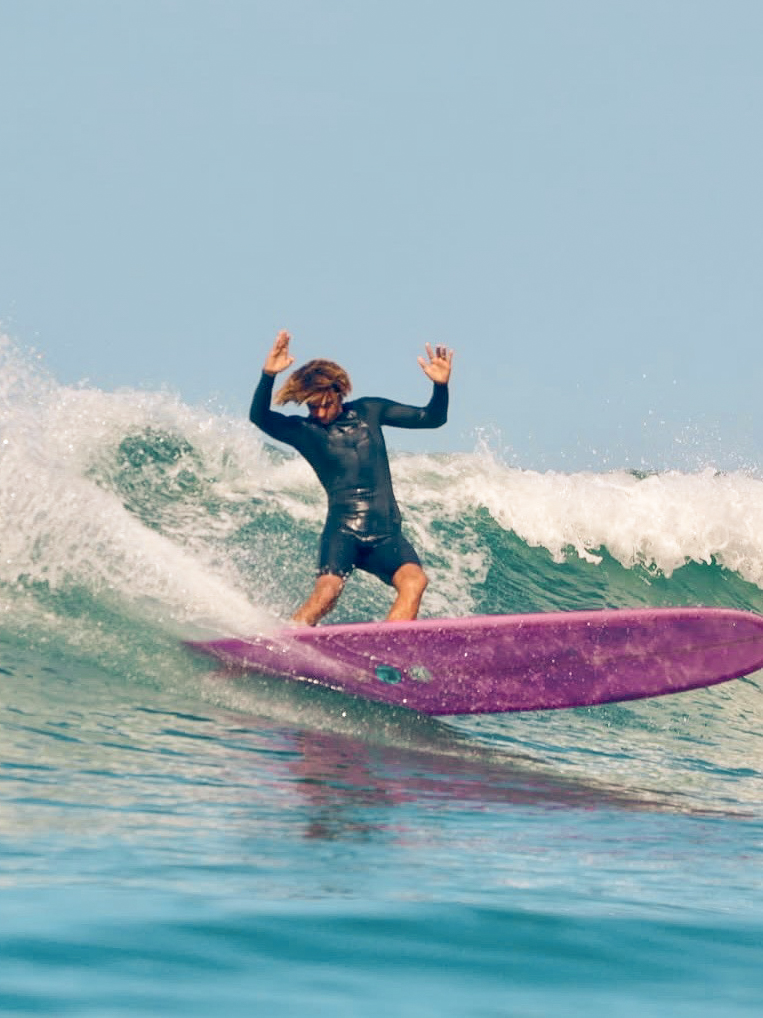 Moroccan local surfer performing a powerful turn on a longboard.